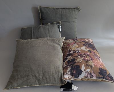 three pillows on a white surface with a tag attached to them