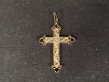 a gold cross with a cross on it sitting on a black surface