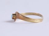 a close up of a gold ring with a blue stone