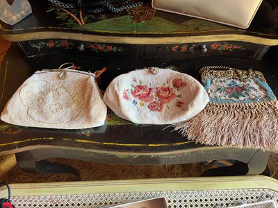three purses sitting on a table with a laptop on it