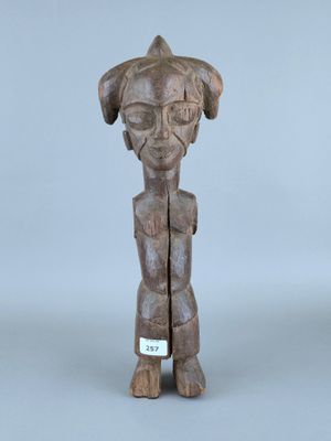 une photo d'une statue en bois représentant un chien, avec une médaille autour du cou