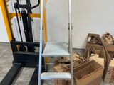 une pile de cartons posée par terre à côté d'un chariot élévateur