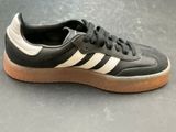 the adidas sneakers are black and white with a light brown sole