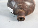 a brown vase with a tag on it sitting on a table