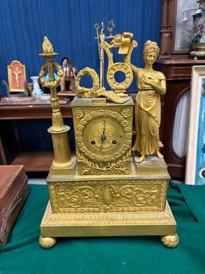une horloge dorée posée sur une nappe verte