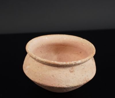 un petit pot en terre cuite posé sur une table noire