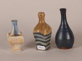three different colored vases sitting next to each other on a table