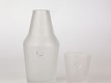 a white vase and a glass on a white surface