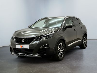 Une voiture grise est garée dans une pièce aux murs blancs.