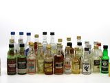 many bottles of alcohol lined up on a white surface