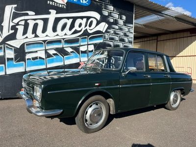 une voiture verte garée devant un immeuble