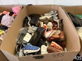 a cardboard box filled with shoes and other items
