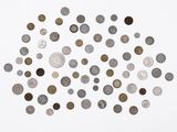 an overhead view of a pile of coins on a white surface