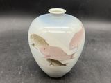 un petit vase blanc orné d'un motif d'oiseau
