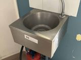 un lavabo situé dans un coin de la salle de bains, muni d'un tuyau