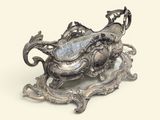 un plateau en argent orné d'un dragon, posé sur un socle