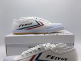 une paire de chaussures blanches ornées de rayures rouges, bleues et blanches