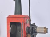 a red machine that is sitting on a wooden stand
