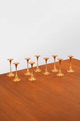 six gold candlesticks sitting on a wooden table