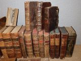 many old books stacked on top of each other on a table