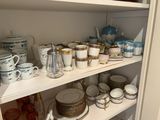many cups and saucers on the shelves in the kitchen