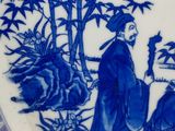 a blue and white plate with a picture of a man and a dog