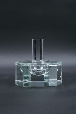 une bouteille en verre vide avec un bouchon noir posée sur une surface noire