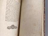 an open book sitting on top of a table next to a white table