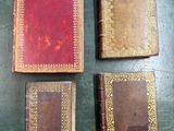 three old books sitting on top of a table next to each other
