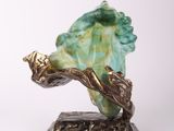 sculpture of a sea shell on a stand with a leaf