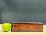a green apple next to a wooden box on a table