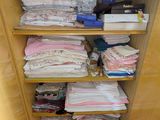 un placard dont les étagères sont remplies de vêtements