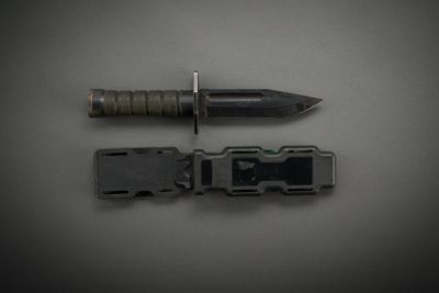 a knife and a screw on a gray surface
