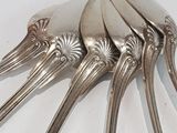 five spoons and a fork on a white table