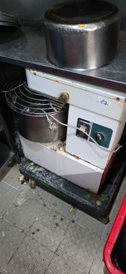 une cuisinière sur laquelle est posée une casserole, à côté d'une poubelle