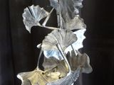 a metal sculpture of a plant with leaves on it