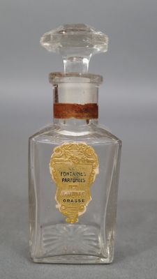 un vieux flacon de parfum à l'étiquette dorée posé sur une table