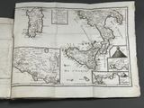 an old book with a map on top of it sitting on top of a table