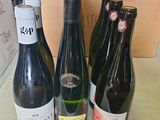 Plusieurs bouteilles de vin sont posées sur une table devant un carton.