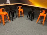 quatre tabourets orange posés dans un coin de la pièce