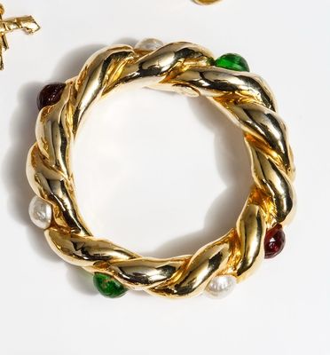 two pieces of jewelry are laying on top of a white surface