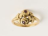 un gros plan d'une bague en or ornée d'une fleur et de feuilles