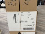 two boxes with stickers on them sitting on a wooden floor
