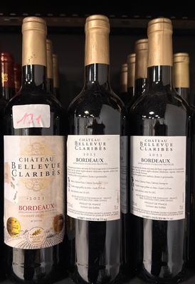 several bottles of wine are lined up on a shelf in a store