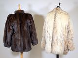 pair of fur coats on a mannequin stand in front of a white wall