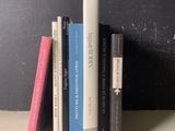 une pile de livres posée sur une étagère près d'un mur noir