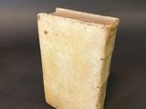 an old book sitting on top of a table next to a black background