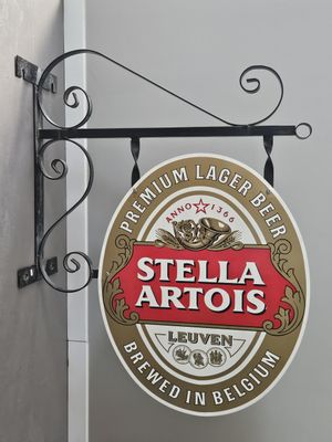 a sign hanging from the side of a building that says stella artus