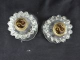 pair of clear glass candle holders with gold accents on a black background