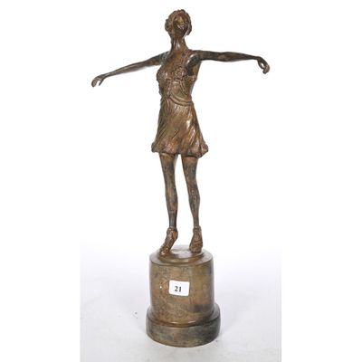 a bronze statue of a woman holding a tennis racquet on a pedestal
